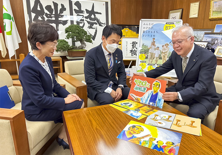 清水市長及び竹居教育長に紙芝居の説明をする岡村会長