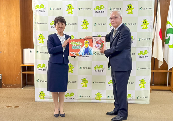 岡村会長から竹居教育長へ紙芝居の寄贈